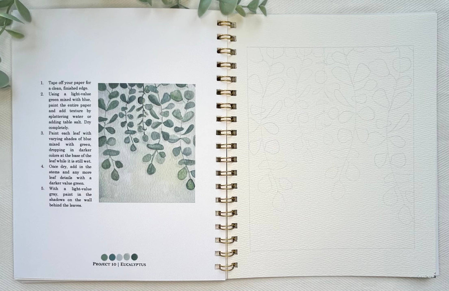 Open notebook with text and a leaf pattern on a textured surface