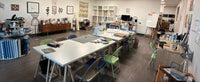 Art classroom with tables, chairs, and art supplies