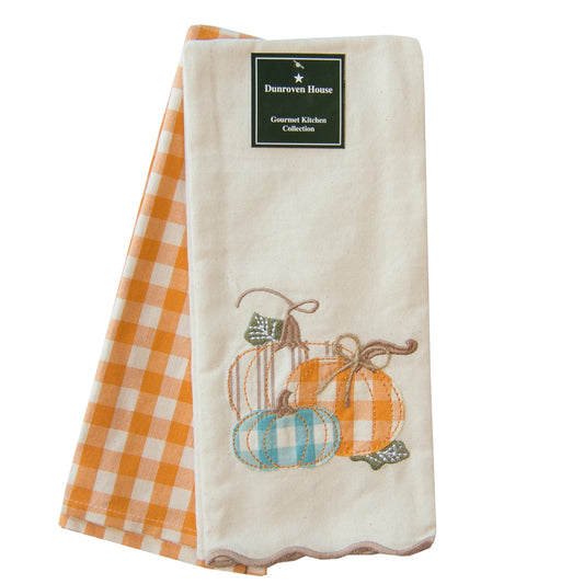 Folded kitchen towel with pumpkin design and checkered pattern on a white background