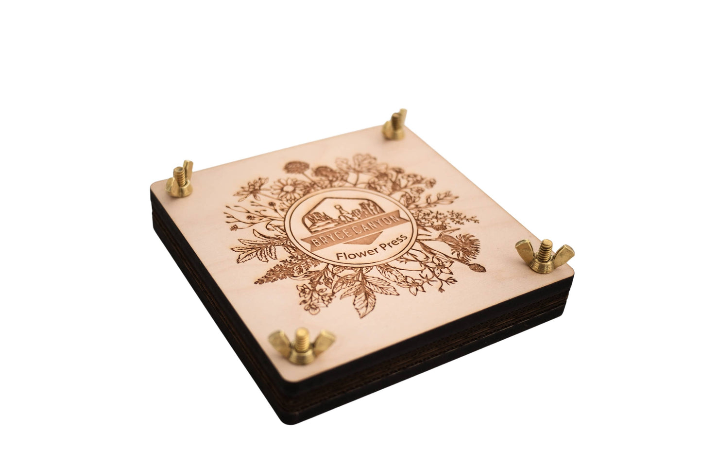 Wooden flower press with engraved design on a white background