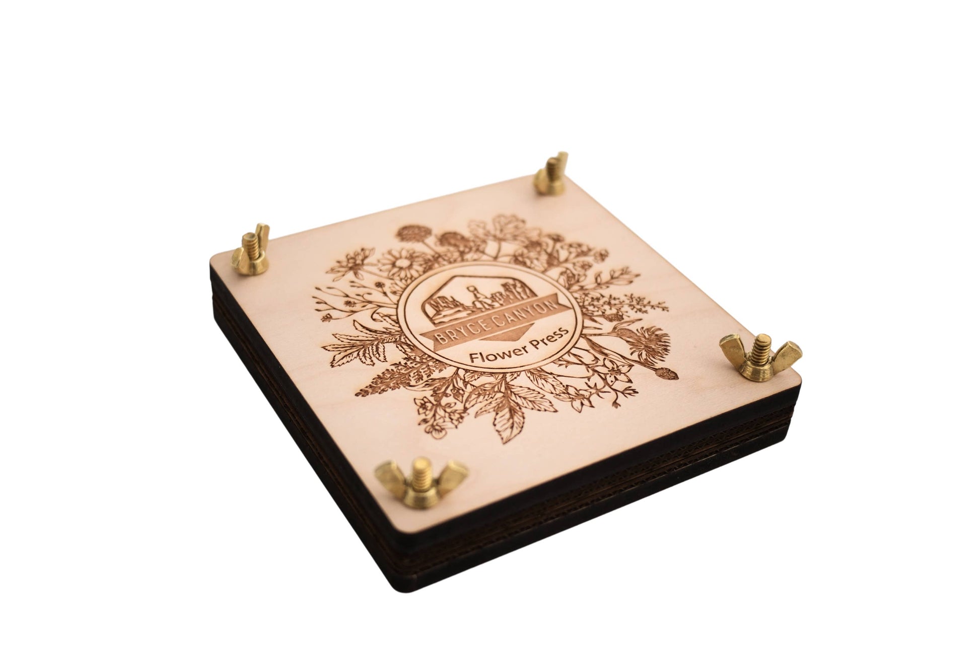 Wooden flower press with engraved design on a white background