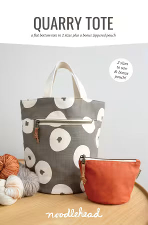 Gray tote bag with white floral patterns and an orange pouch on a wooden surface, with 'noodlehead' branding.