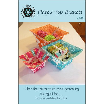 Flared top baskets with colorful designs on a white surface, featuring the brand 'Living the Dream'.