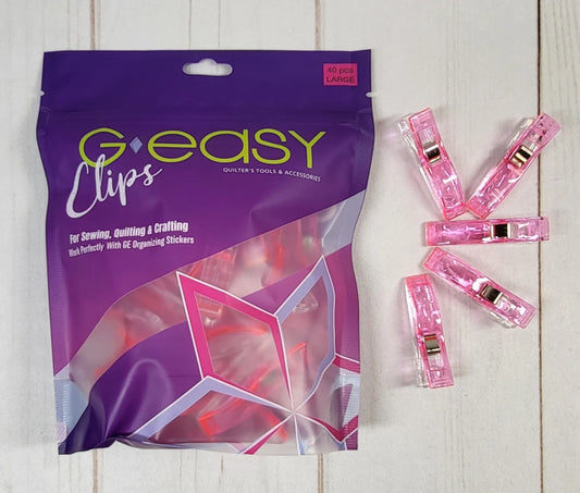 Purple package of G-easy Clips with pink clips on a wooden surface