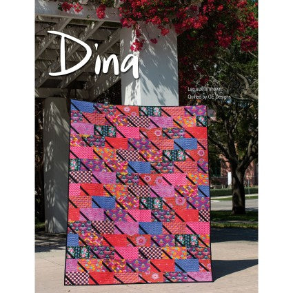 Colorful quilt displayed outdoors with 'Dina' branding.