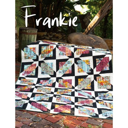 Colorful quilt with geometric pattern on a wooden surface outdoors