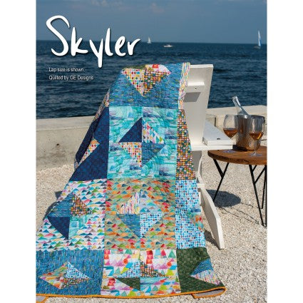 Colorful quilt displayed outdoors with a scenic ocean background