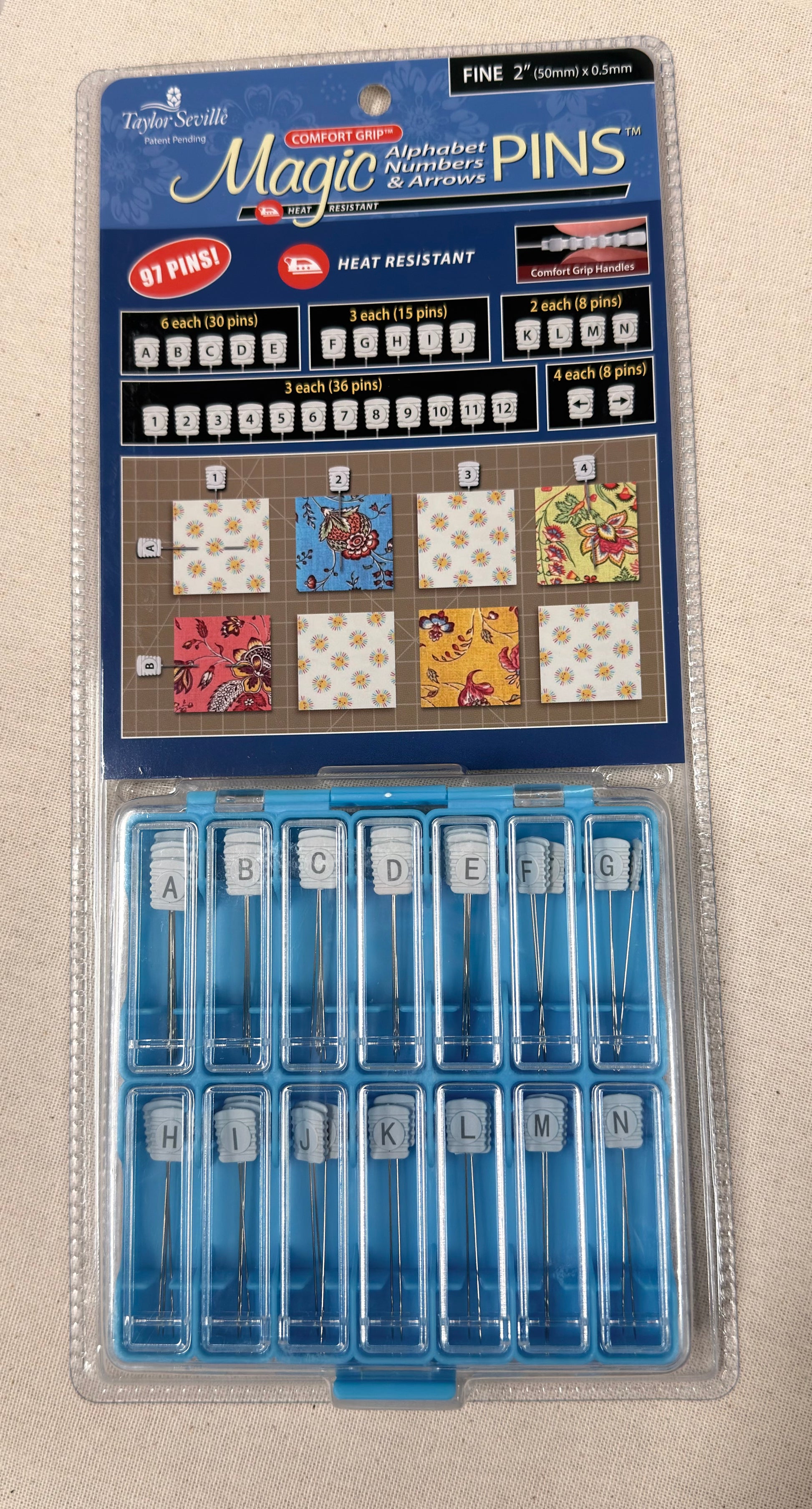 Packaged set of Magic Pins with letter and number pins on a beige background