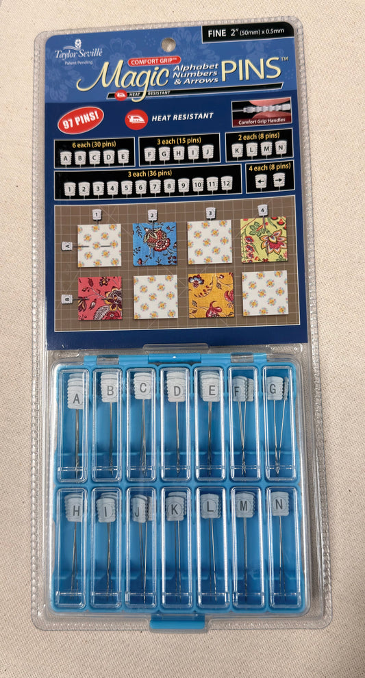 Packaged set of Magic Pins with letter and number pins on a beige background