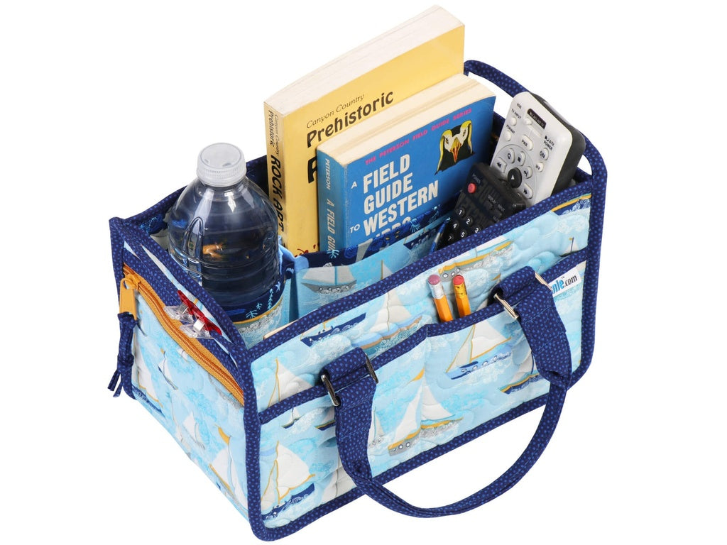 Multifunctional bag with compartments holding books, a bottle, and remote controls on a white background