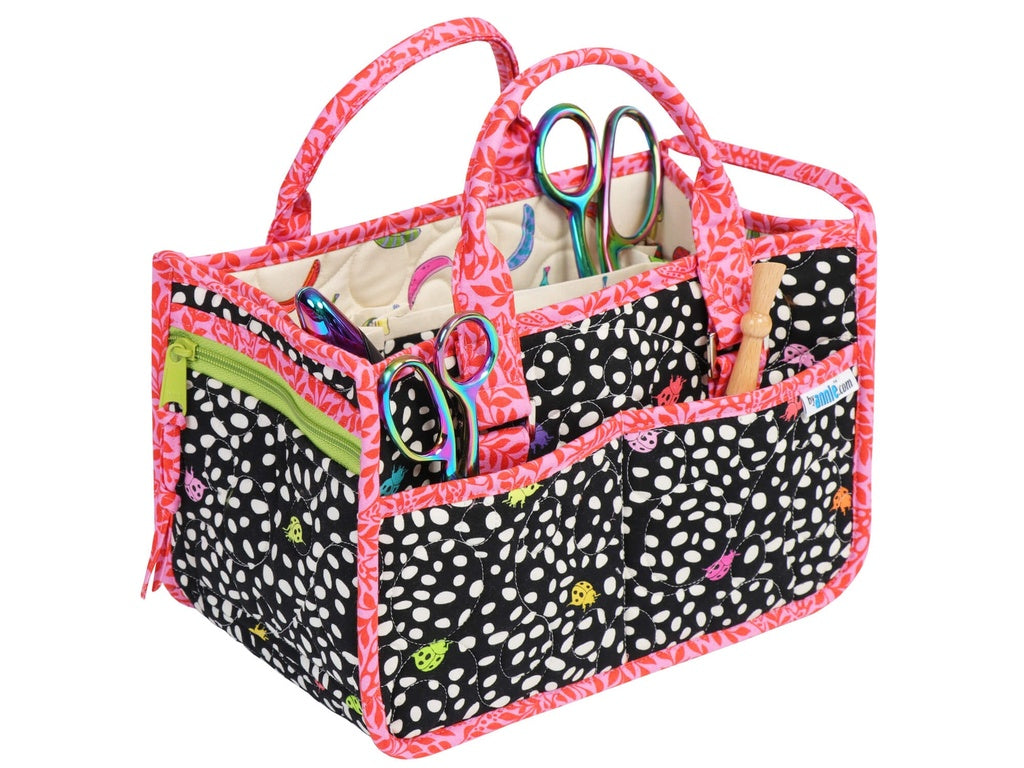 Multicolored polka dot craft caddy with scissors and other tools on a white background