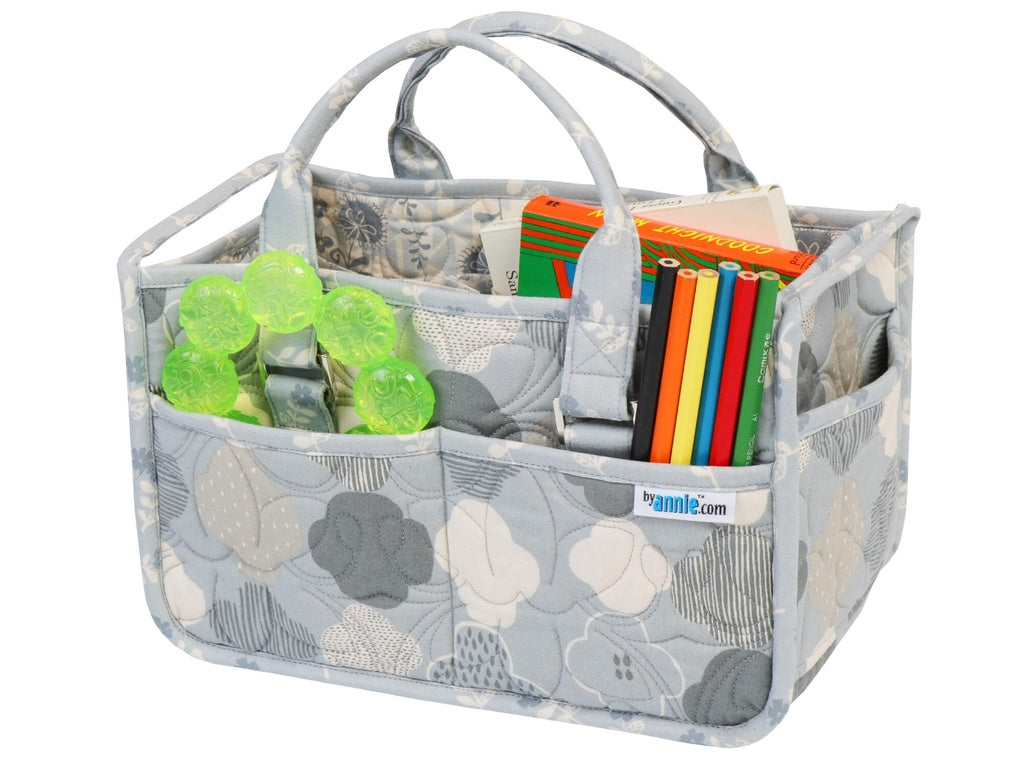 Gray floral-patterned caddy with compartments filled with items on a white background