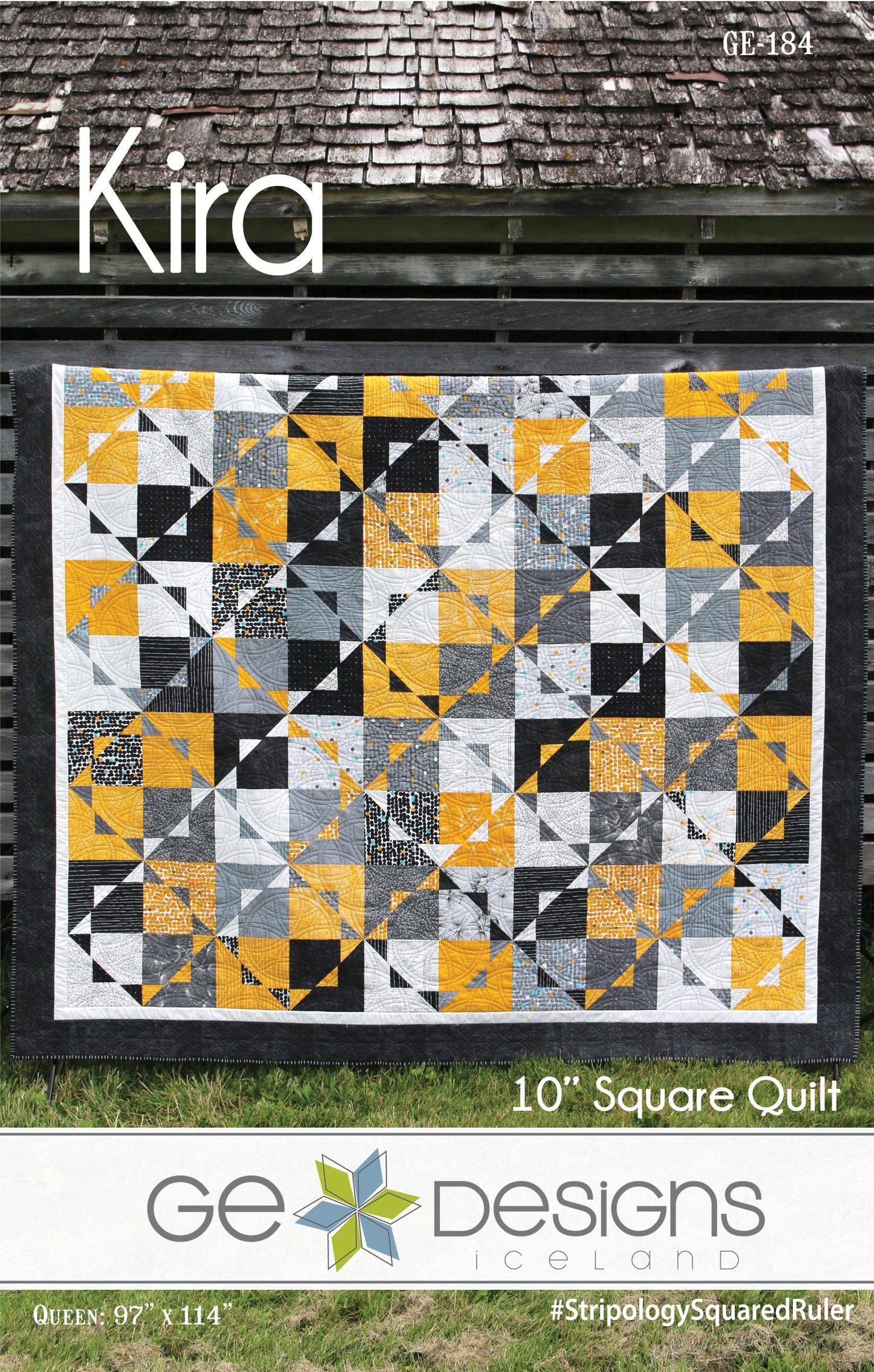 Quilt with geometric pattern on a grassy background, featuring the brand 'GE Designs'.