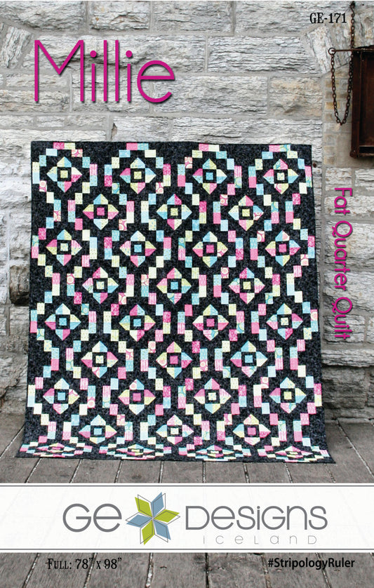 Quilt with geometric pattern on a wooden floor, featuring the brand 'GE Designs'.