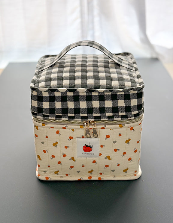 Checkered fabric bag with a patterned base on a gray surface