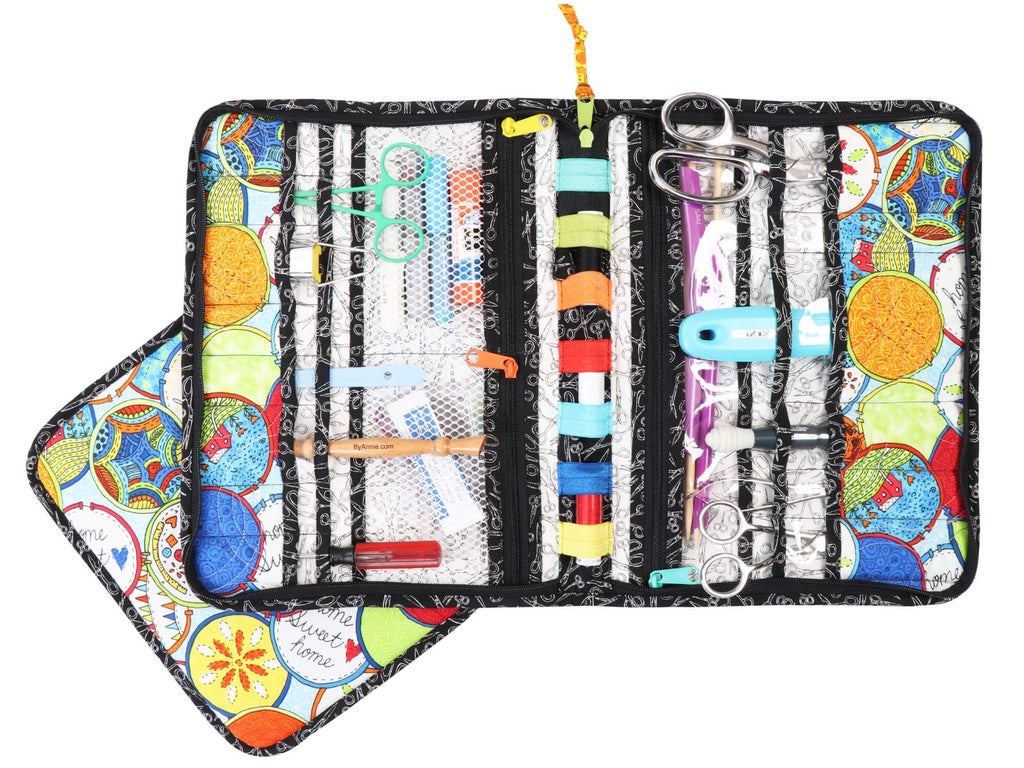 Colorful sewing kit with various tools inside a patterned case on a white background
