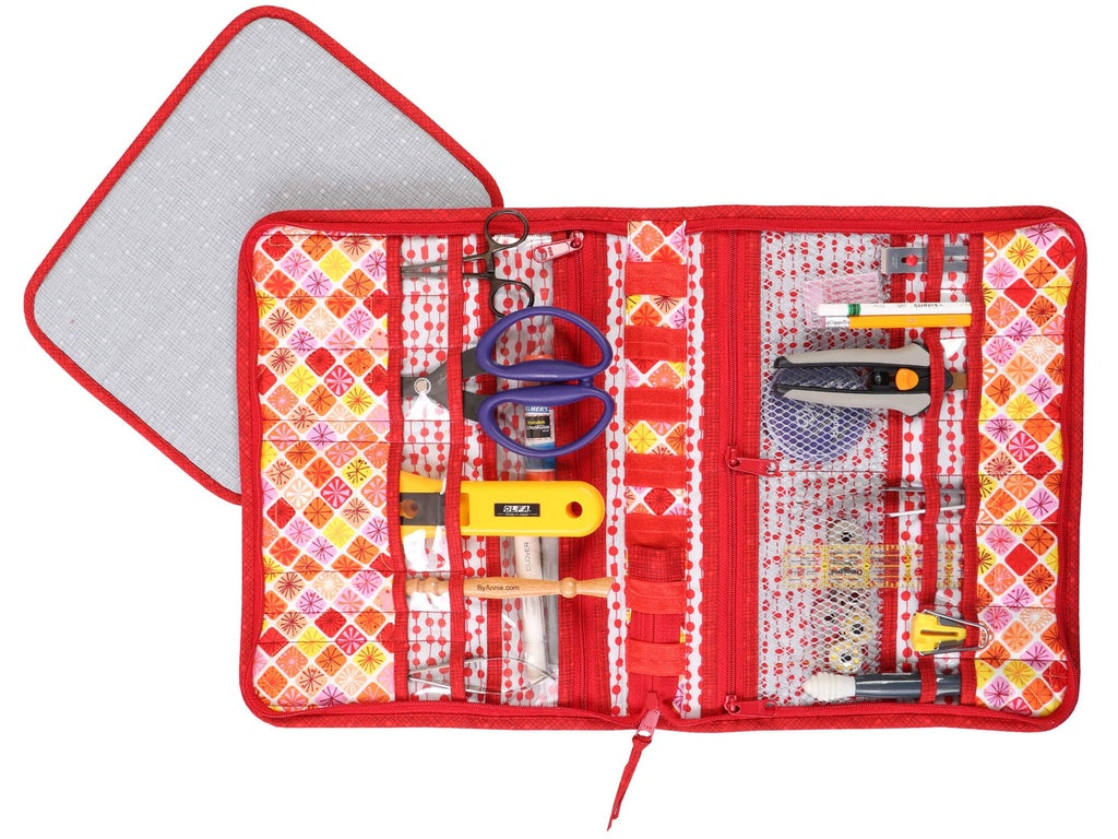 Red sewing kit with various tools on a white background
