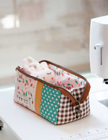 Patchwork pouch with polka dots and stripes on a sewing machine