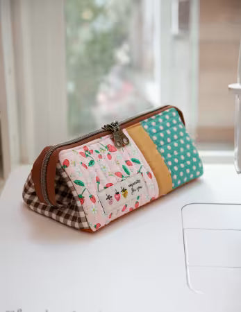 Multicolored fabric pouch with patterned design on a white surface