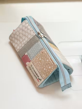 Patchwork-style pouch with zipper on a white background