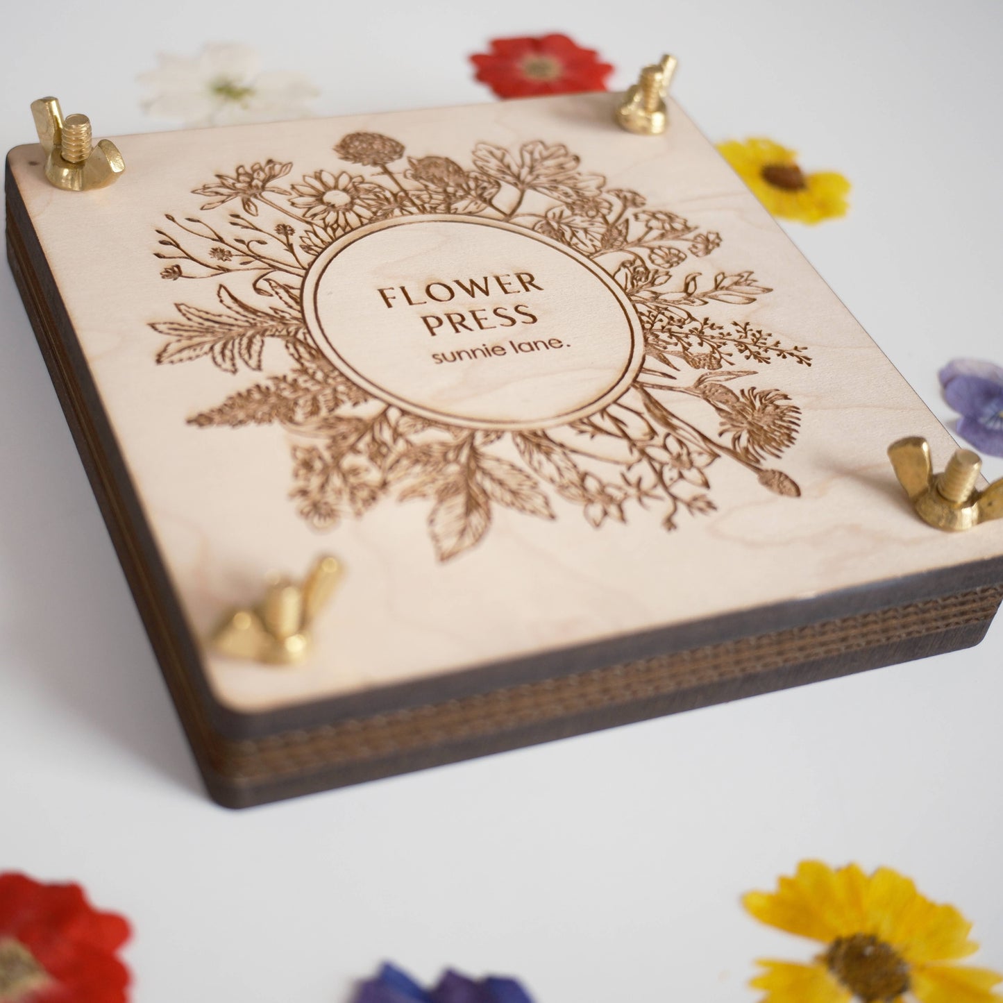 Wooden flower press with floral design and 'Flower Press' branding on a light background.