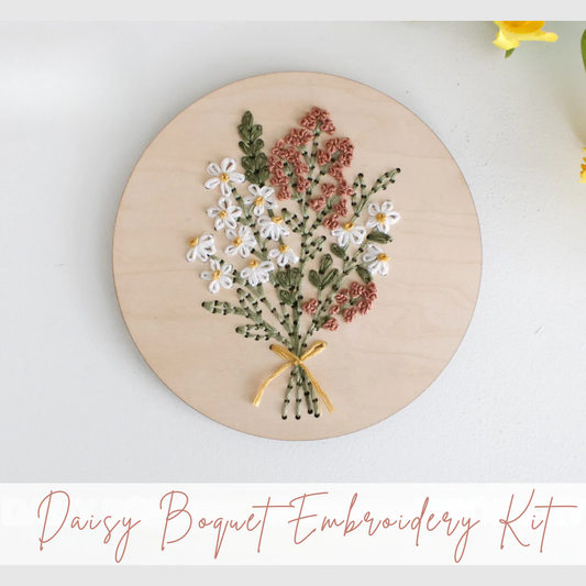 Embroidery hoop with a daisy bouquet design on a white background