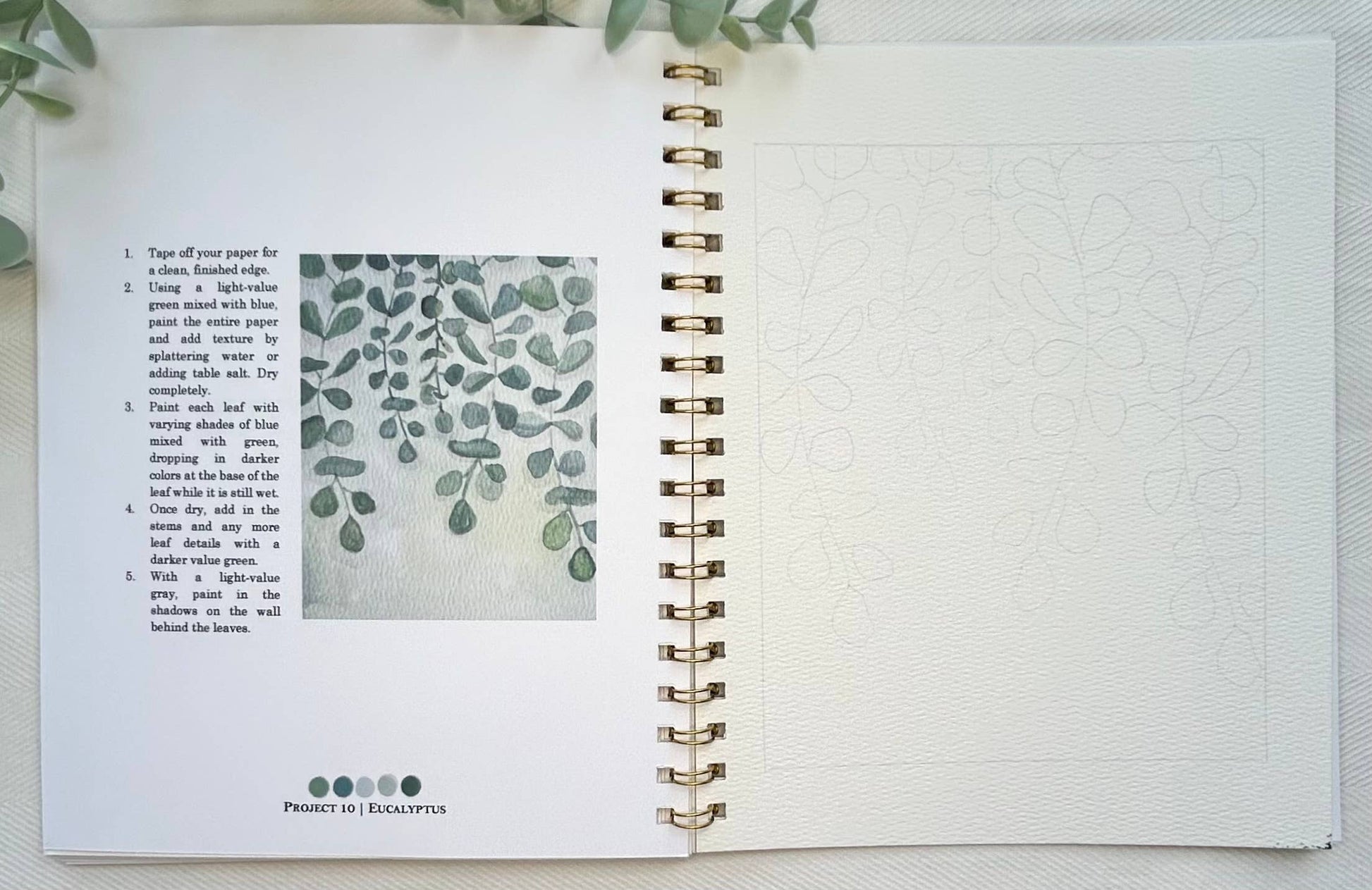 Open notebook with text and a leaf pattern on a textured surface